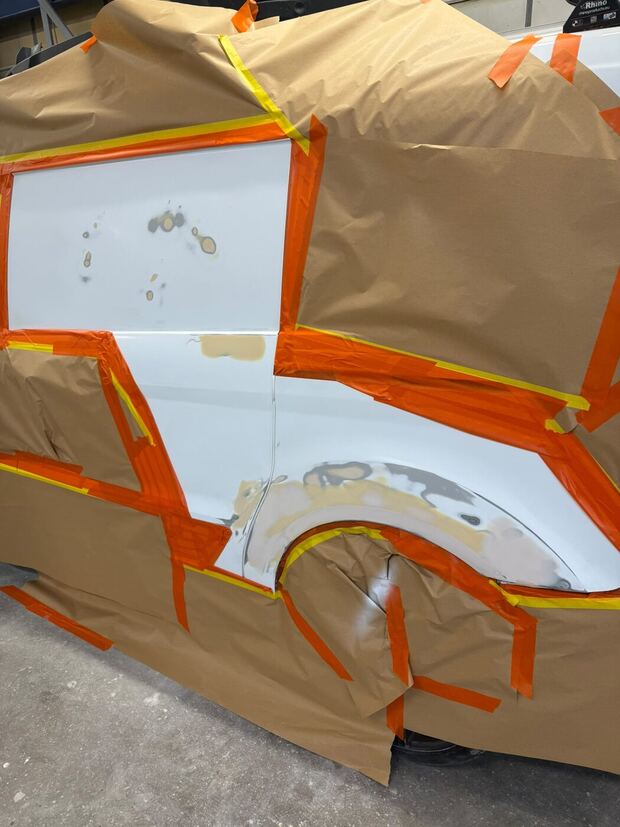 White van panel masked up with filler showing through the primer