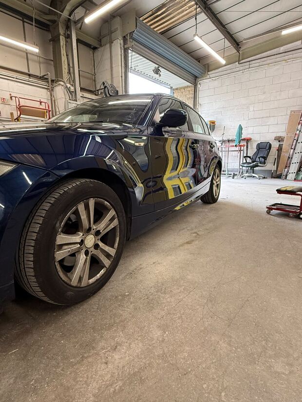 The same BMW back in the workshop with the replacement door on and the side painted