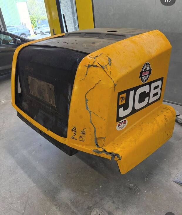 Yellow JCB engine cover with a long crack running through the front corner and a piece broken off the bottom
