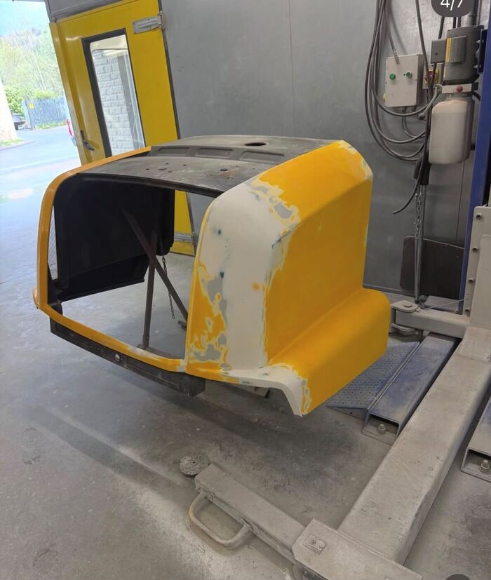 The same JCB panel sanded back flat and primed, ready for paint